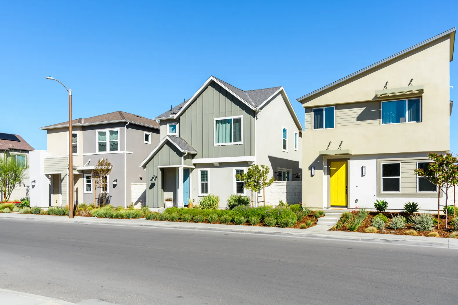 A street of new homes with a footpath in daylight