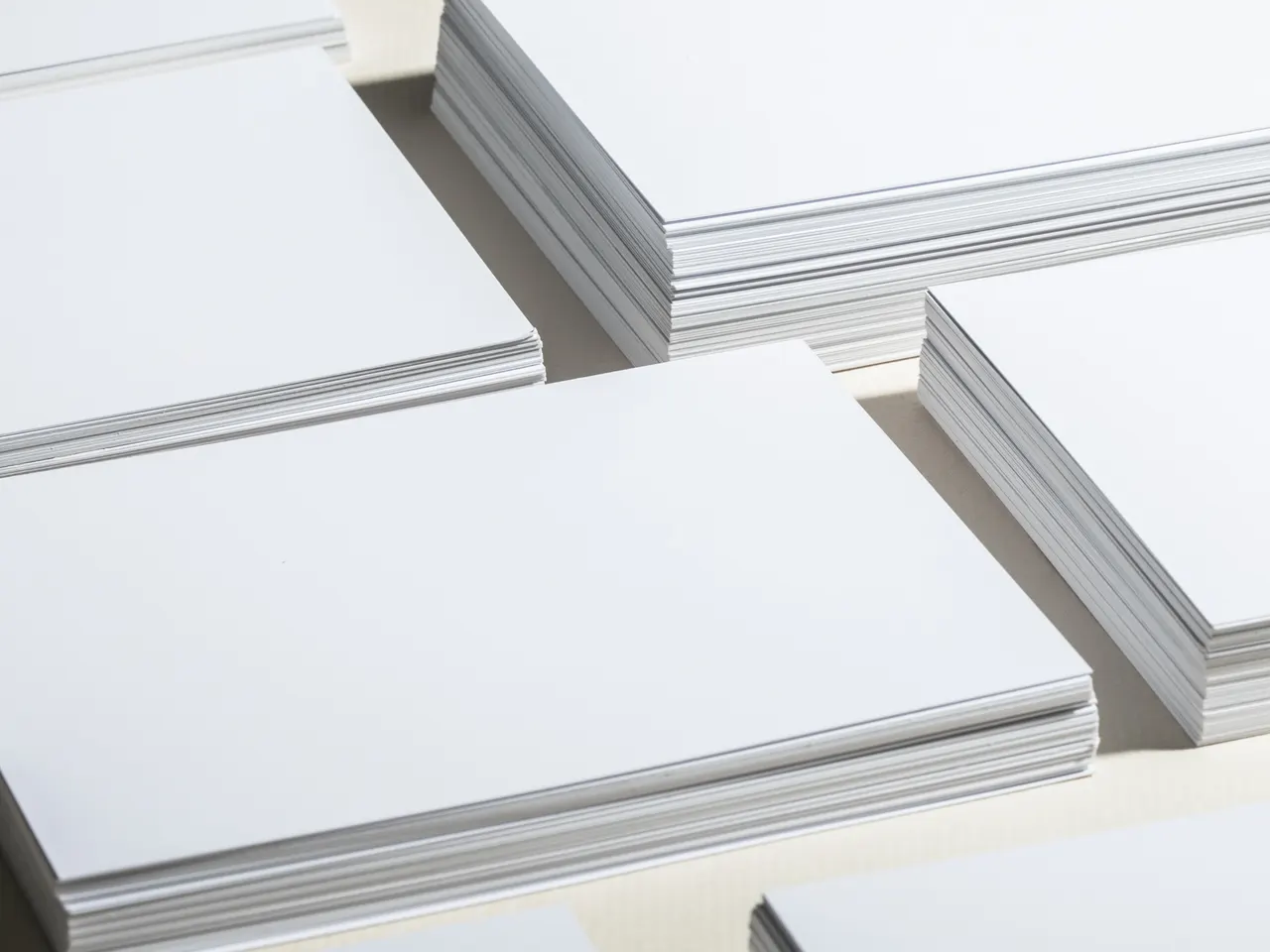 Stacks of white card stock laid out in rows